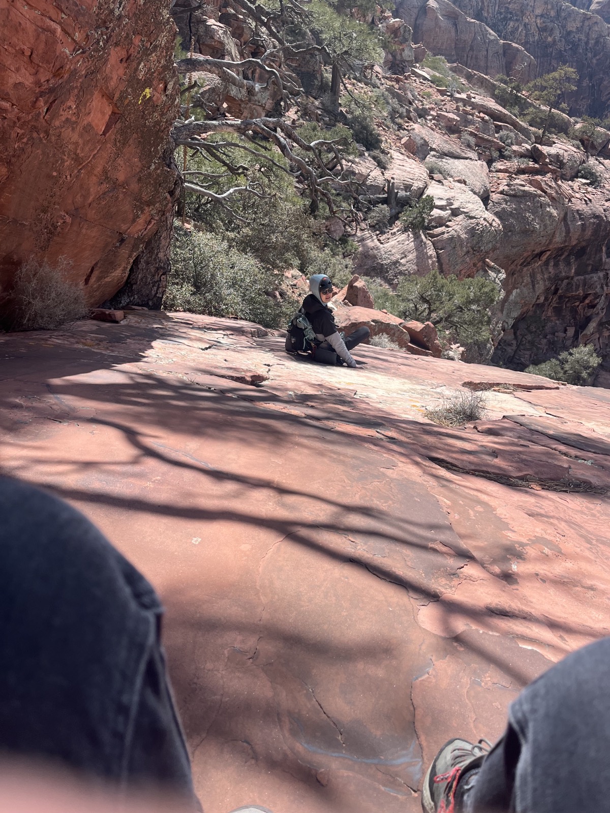 Cathy standing on a high, exposed sandstone ridge during the descent